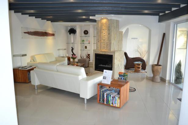 Ein Wohnzimmer mit weißen Sofas und einem Steinkamin.