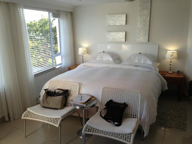 Ein Schlafzimmer mit einem großen Bett, zwei Stühlen und zwei Nachttischen.