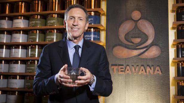Ein Mann im Anzug hält eine Tasse Tee vor einem Teavana-Logo.