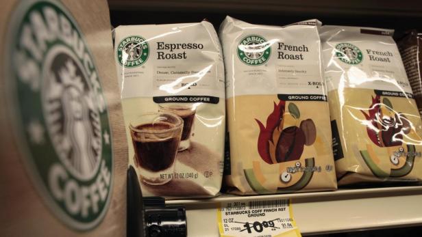 Mehrere Packungen Starbucks-Kaffee, darunter Espresso Roast und French Roast, stehen im Regal.