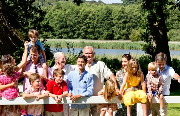 Die dänische Königsfamilie posiert vor einer ländlichen Kulisse für ein Gruppenfoto.