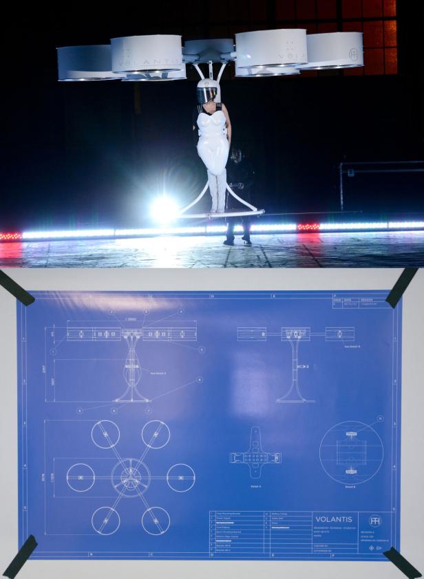 Eine Frau in weißem Anzug steht auf einer Plattform, die von einer Drohne getragen wird. Im Vordergrund ein Bauplan der Drohne.