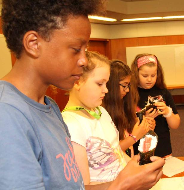 Eine Gruppe von Kindern betrachtet und untersucht Gegenstände in ihren Händen.