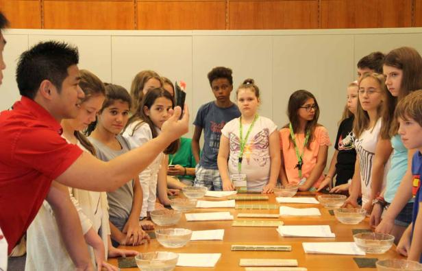 Eine Gruppe von Kindern lernt, wie man Sushi zubereitet.