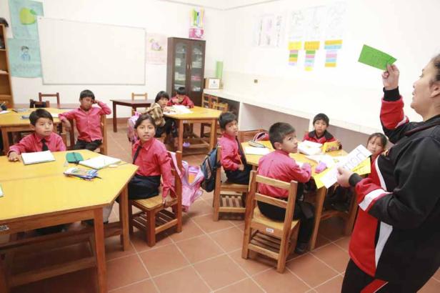 Eine Lehrerin unterrichtet eine Gruppe von Schülern in einem Klassenzimmer.