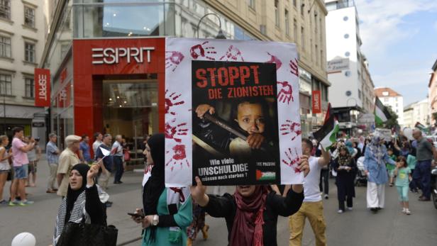 Eine Demonstration mit palästinensischen Flaggen und einem Plakat mit der Aufschrift „Stoppt die Zionisten“.