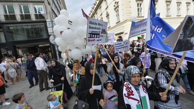 Eine Demonstration mit palästinensischen Flaggen und Transparenten in einer Stadt.