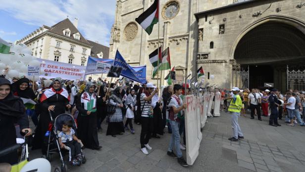 Eine Demonstration mit palästinensischen Flaggen und Transparenten in einer Stadt.