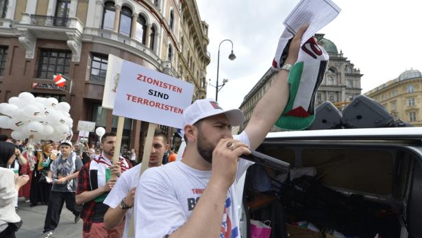 Eine Demonstration mit Schildern und palästinensischen Flaggen in einer Stadt.