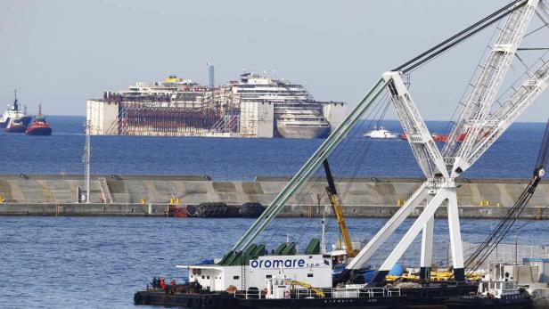Die teilweise abgetragene Costa Concordia liegt vor der Küste im Wasser.