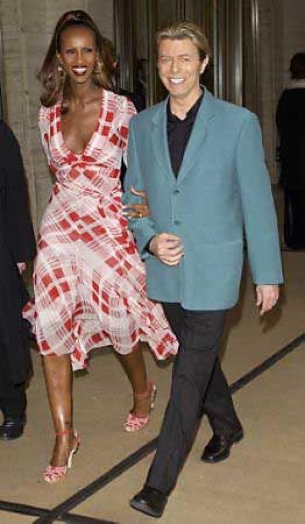 Iman und David Bowie gehen Arm in Arm.