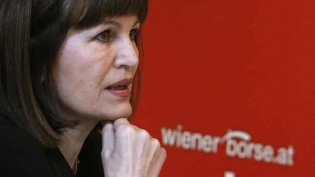 Vienna Stock Exchange management board member Kura Eine Frau mit braunen Haaren vor einem roten Hintergrund mit dem Logo der Wiener Börse.