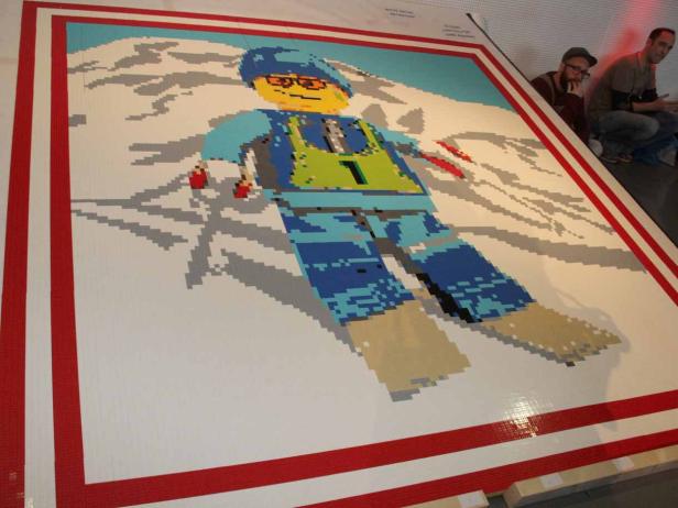 Ein großes Lego-Mosaik zeigt einen Skifahrer in den Bergen.