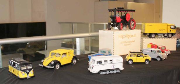 Eine Ausstellung von verschiedenen Fahrzeugmodellen aus Lego, darunter ein Traktor und ein VW-Bus.