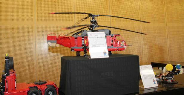 Ein roter Modellhubschrauber Kamov KA-32 aus Lego steht auf einem Tisch.