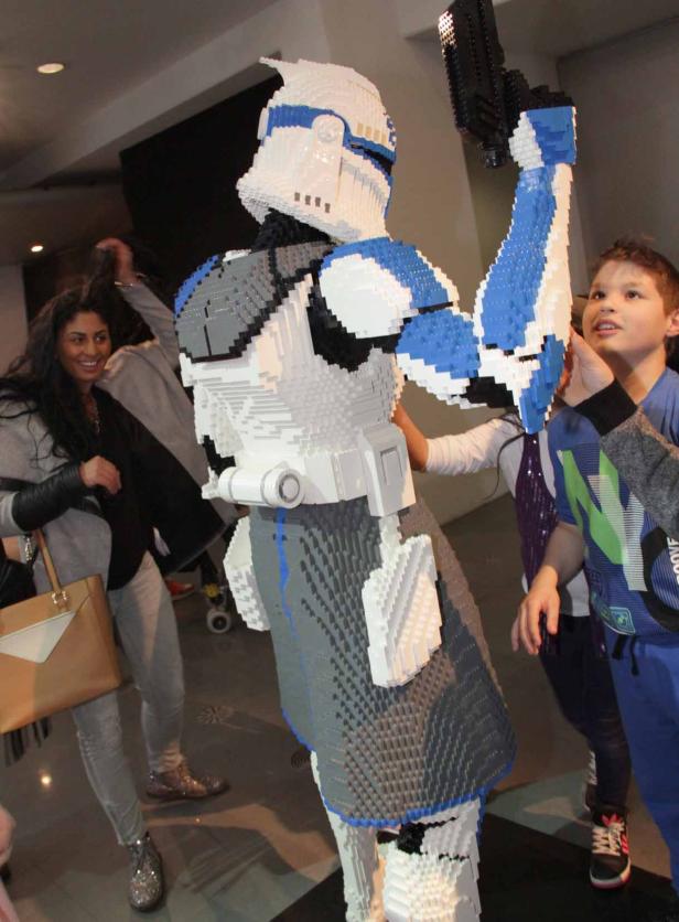 Ein Clone Trooper aus „Star Wars“, gebaut aus Legosteinen, wird von Kindern bestaunt.