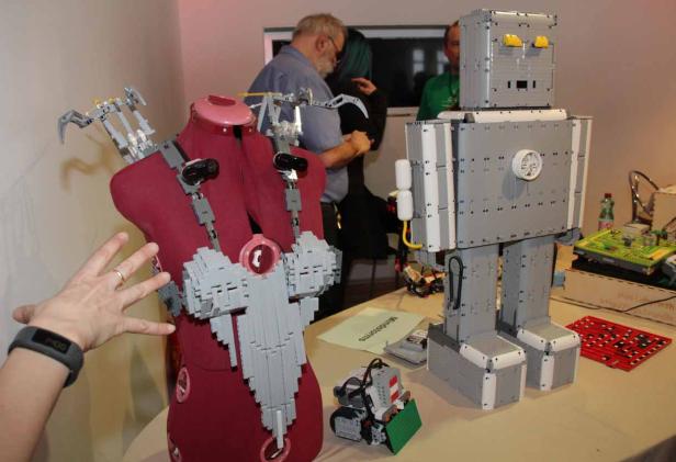 Ein aus Legosteinen gebauter Roboter und eine Schaufensterpuppe mit Lego-Applikationen stehen auf einem Tisch.