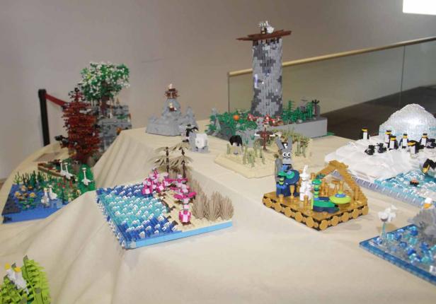 Mehrere Lego-Dioramen sind auf einem Tisch ausgestellt.
