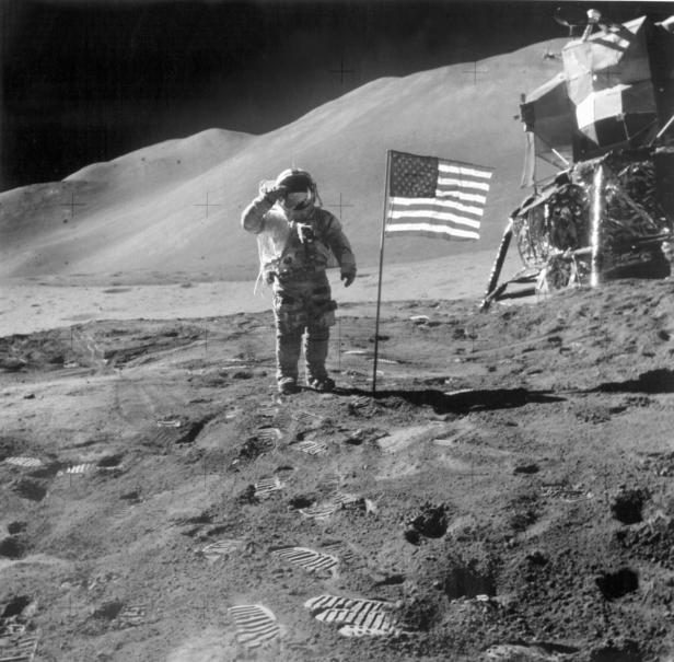 Mondlandung - Apollo 15 Ein Astronaut salutiert neben der US-Flagge auf der Mondoberfläche.