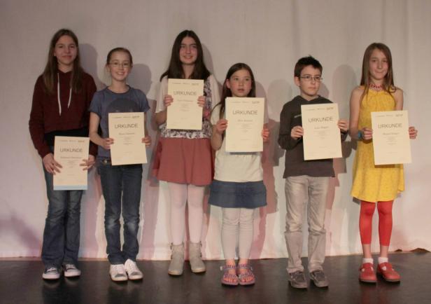 Eine Gruppe Kinder hält Urkunden in den Händen.