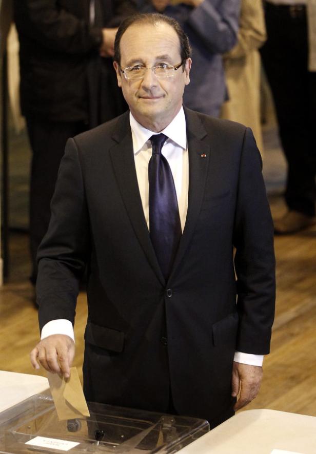 François Hollande wirft einen Stimmzettel in eine Wahlurne.