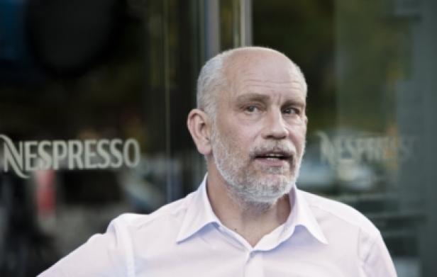John Malkovich steht vor einem Nespresso-Geschäft.