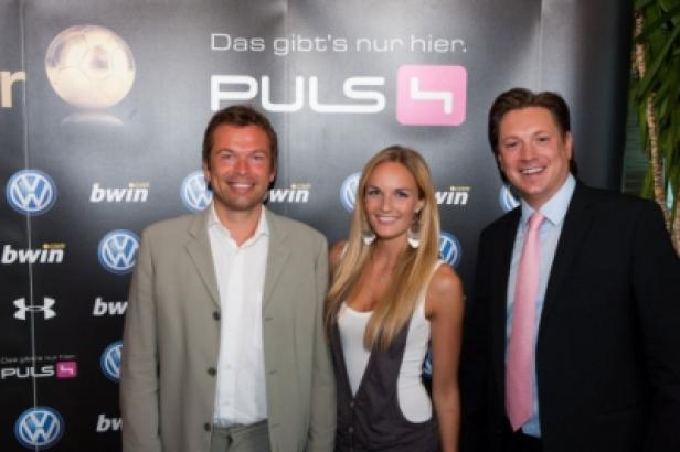 Drei Personen posieren vor einer Wand mit Logos von Puls 4, Volkswagen und Bwin.