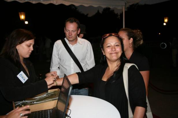 Eine Frau erhält ein Armband an einem Empfangstisch.