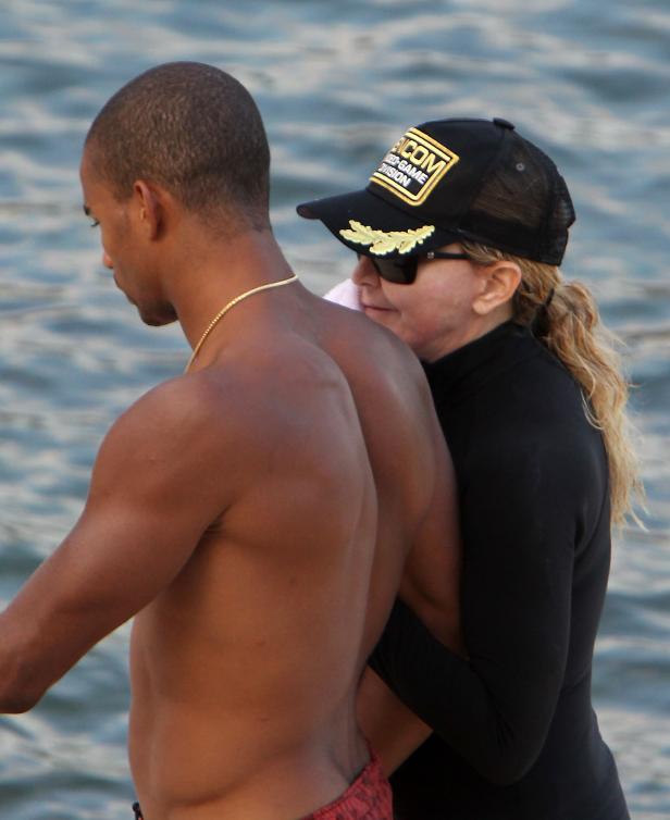 Madonna umarmt einen Mann am Strand.