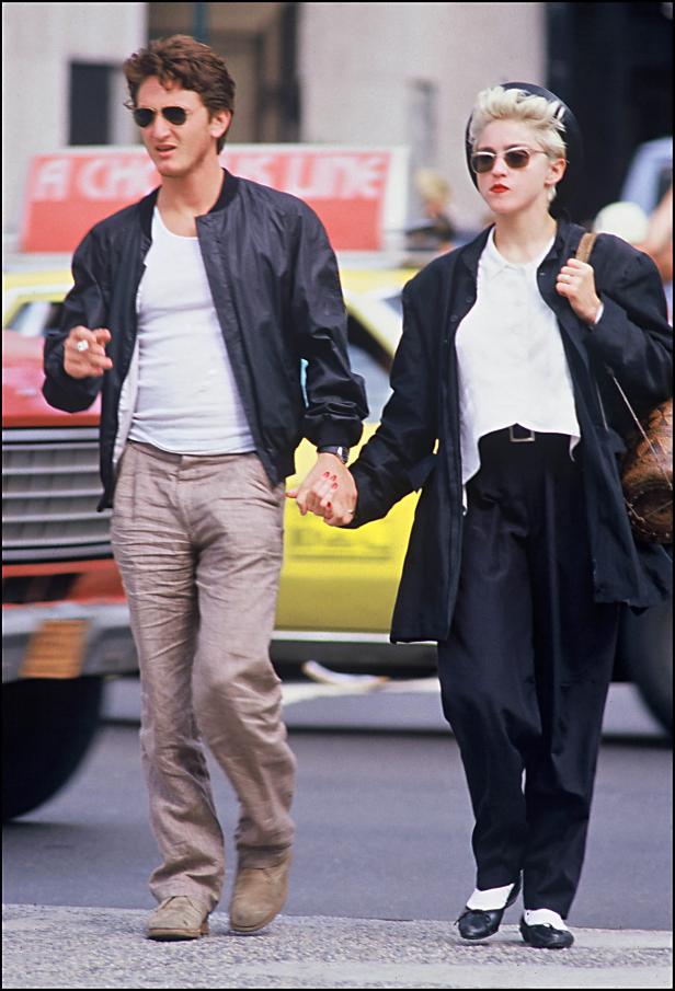 Madonna und Sean Penn gehen Händchen haltend auf einer Straße entlang.