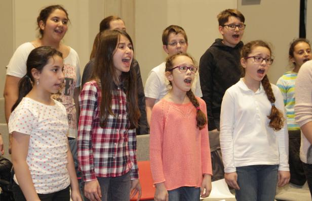 Eine Gruppe von Kindern singt gemeinsam in einem Chor.