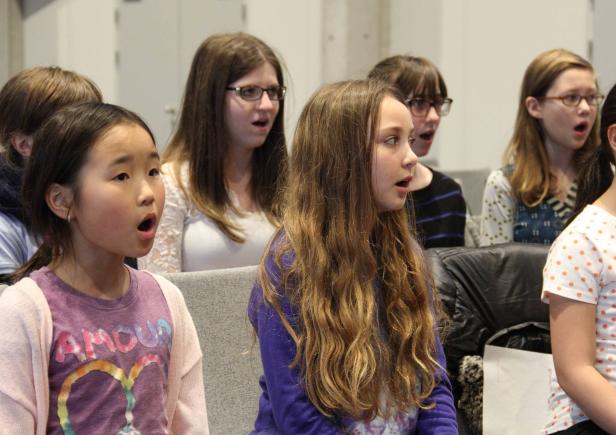 Eine Gruppe junger Mädchen singt in einem Chor.