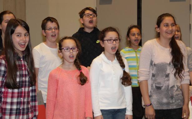 Eine Gruppe von Kindern singt gemeinsam in einem Chor.