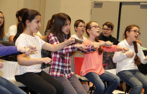 Eine Gruppe von Kindern sitzt und singt in einem Chor.