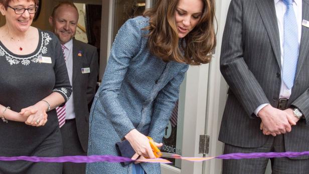 Catherine, Princess of Wales, durchschneidet ein lila Band bei einer Veranstaltung.