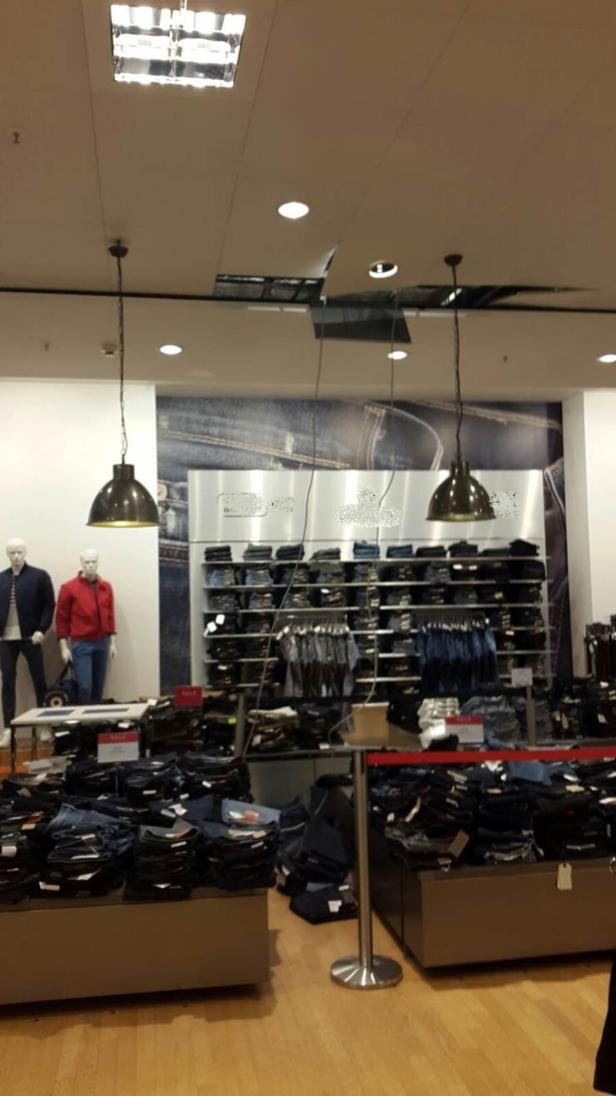 In einem Bekleidungsgeschäft werden Jeans auf Tischen und Regalen präsentiert.