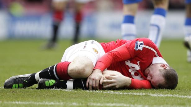 Ein Fußballspieler liegt verletzt auf dem Rasen.