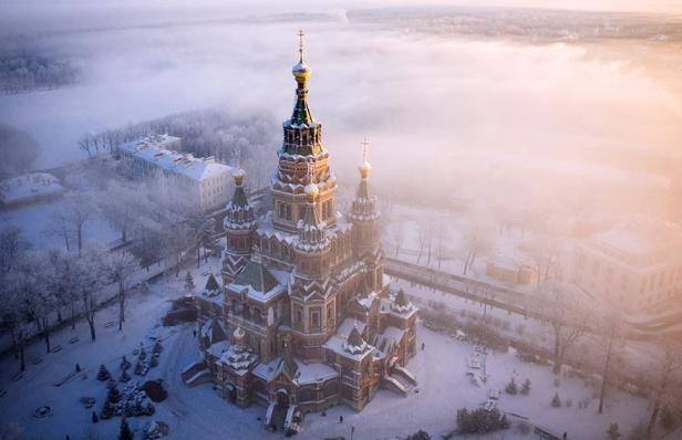 Eine russisch-orthodoxe Kirche im Winternebel, aufgenommen aus der Vogelperspektive.