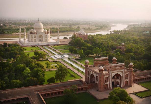 Luftaufnahme des Taj Mahal mit Gärten und dem Fluss Yamuna im Hintergrund.