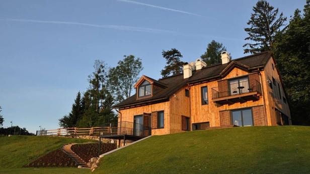 Dialogzentrum Phönixberg Ein modernes Holzhaus mit Balkonen steht auf einem grünen Hügel.