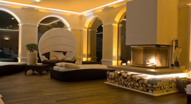 Ein luxuriöser Raum mit Kamin und einem runden Bett mit Baldachin.