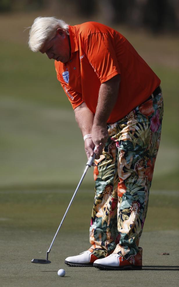 Ein Golfspieler in auffälligen Hosen beim Putten auf dem Grün.