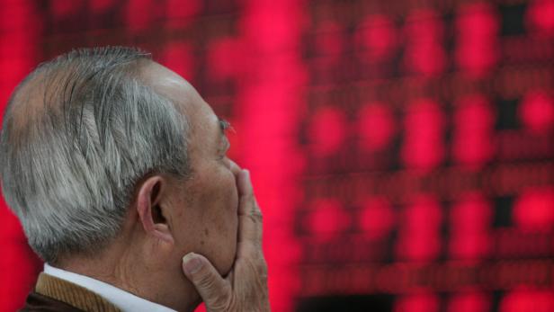 Ein älterer Mann blickt besorgt auf eine rote Anzeigetafel.