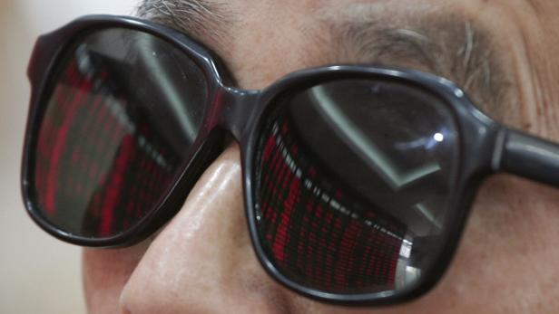 In der Sonnenbrille einer Person spiegelt sich eine Anzeigetafel mit Börseninformationen.