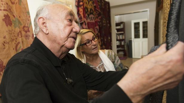 Ein älterer Mann und eine Frau betrachten gemeinsam ein Stoffmuster.