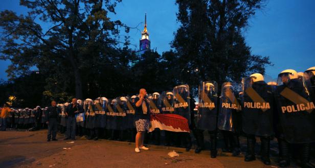 Eine Reihe von Polizisten in Schutzausrüstung steht vor einem Gebäude.