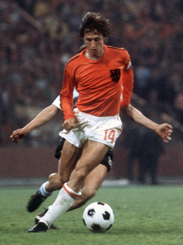 Johan Cruyff mit der Nummer 14 am Ball während eines Fußballspiels.