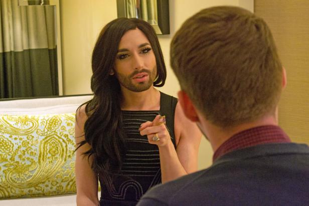 Conchita Wurst zeigt mit dem Finger auf eine Person.