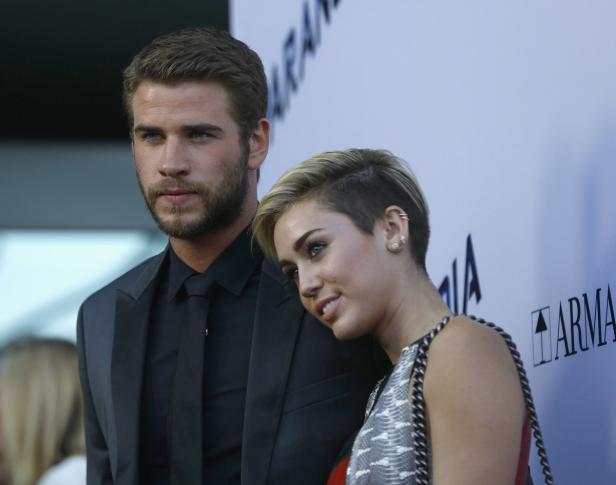 Liam Hemsworth und Miley Cyrus posieren zusammen auf dem roten Teppich.