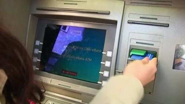 Rettungsplan für Zypern bis Montag Eine Person benutzt einen Geldautomaten der Laiki eBank.